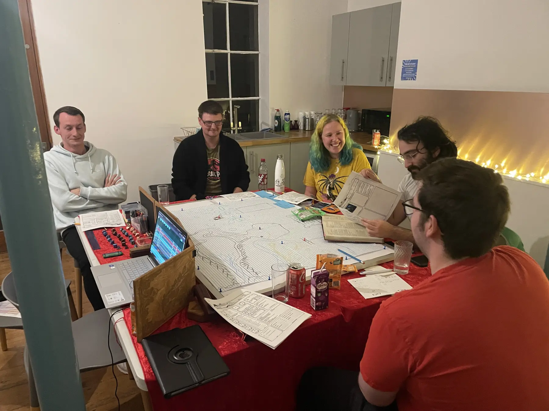 A mixed adult group sharing a tabletop adventure around a map-filled table