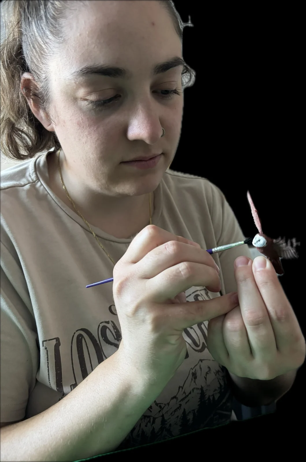 A hobbyist carefully painting a miniature by hand