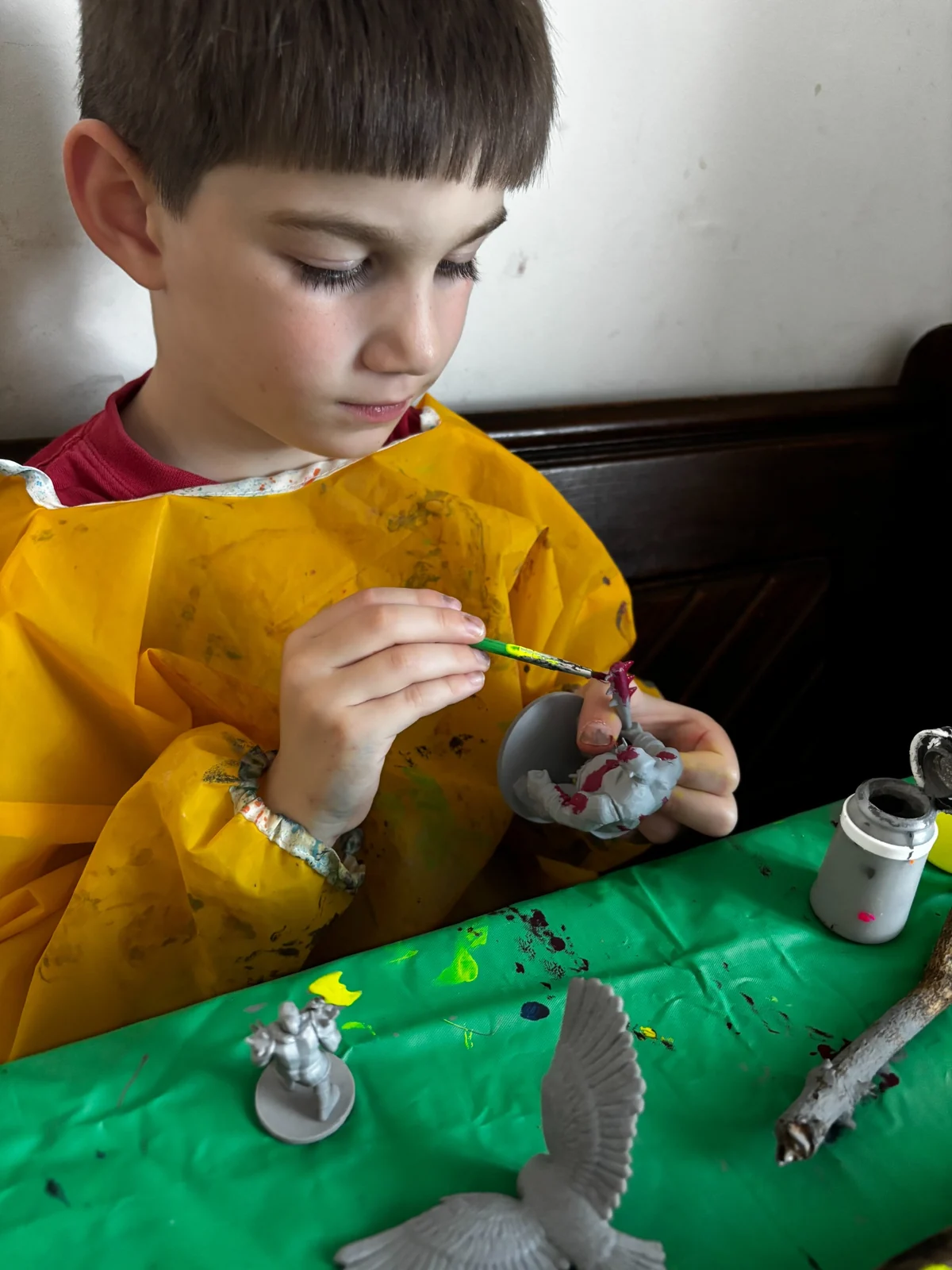 Young Creator carefully painting a miniature at the table